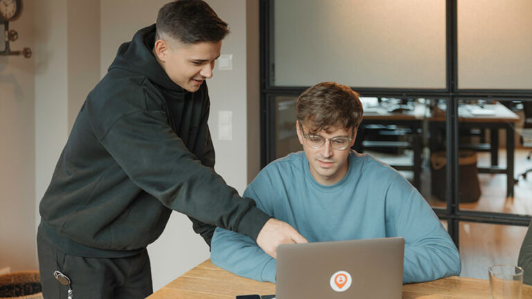 Arbeitszeiterfassung: Pflichten, Verstöße und Bußgelder Person zeigt anderer Person etwas am Laptop