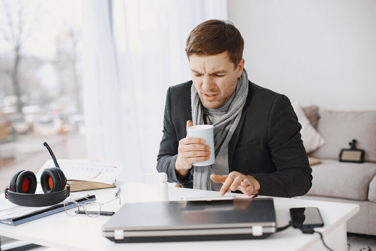 Arbeitsunfähigkeitsbescheinigung und Krankmeldung beim Arbeitgeber: So geht’s! Person krank im Büro
