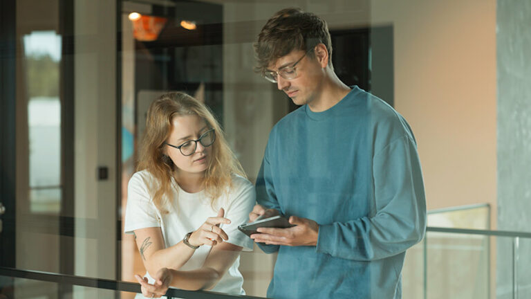 Interview: “Digitale Tools wie Team-Urlaubsplaner erhöhen die Motivation und unterstützen den Projekt-Erfolg" Mitarbeitende am iPad