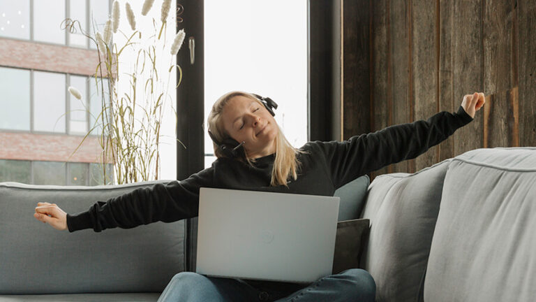 Person im Homeoffice streckt sich