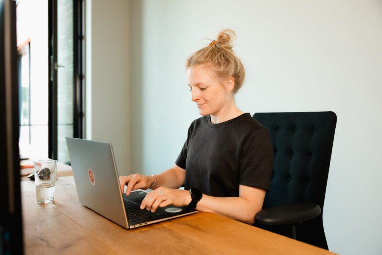 Mitarbeitende am Laptop trägt Urlaub für Elternzeit ein